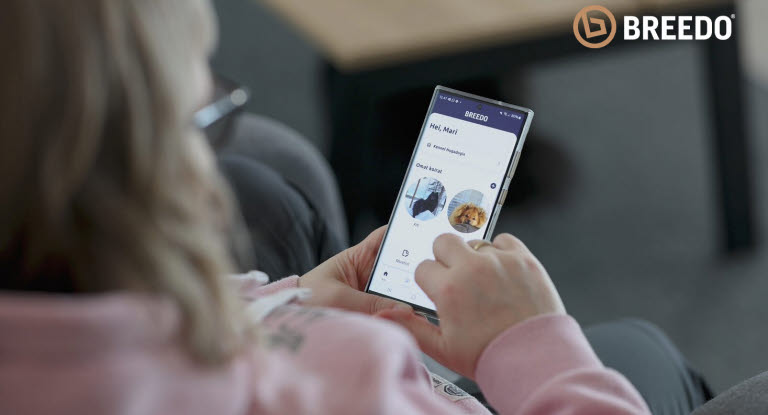 Nainen katselee Breedo-sovellusta puhelimellaan
