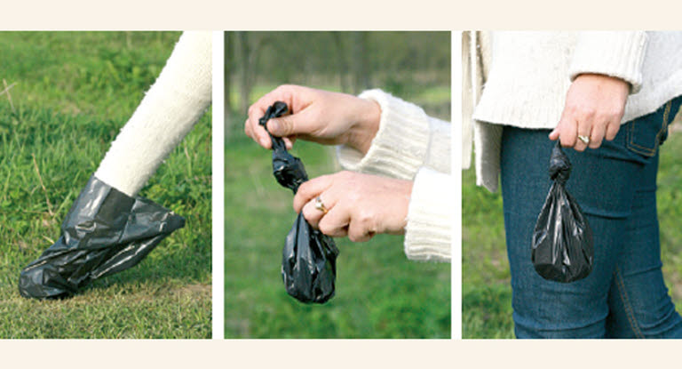 Nainen kerää koiran kakan pussiin.